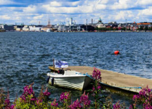Small boat at a dock in Lonna Island with sea and Helsinki skyline on the background